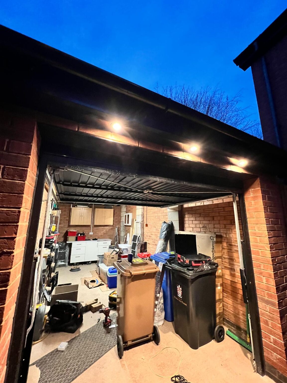 Outdoor garage with new soffit downlights and workspace lighting installation