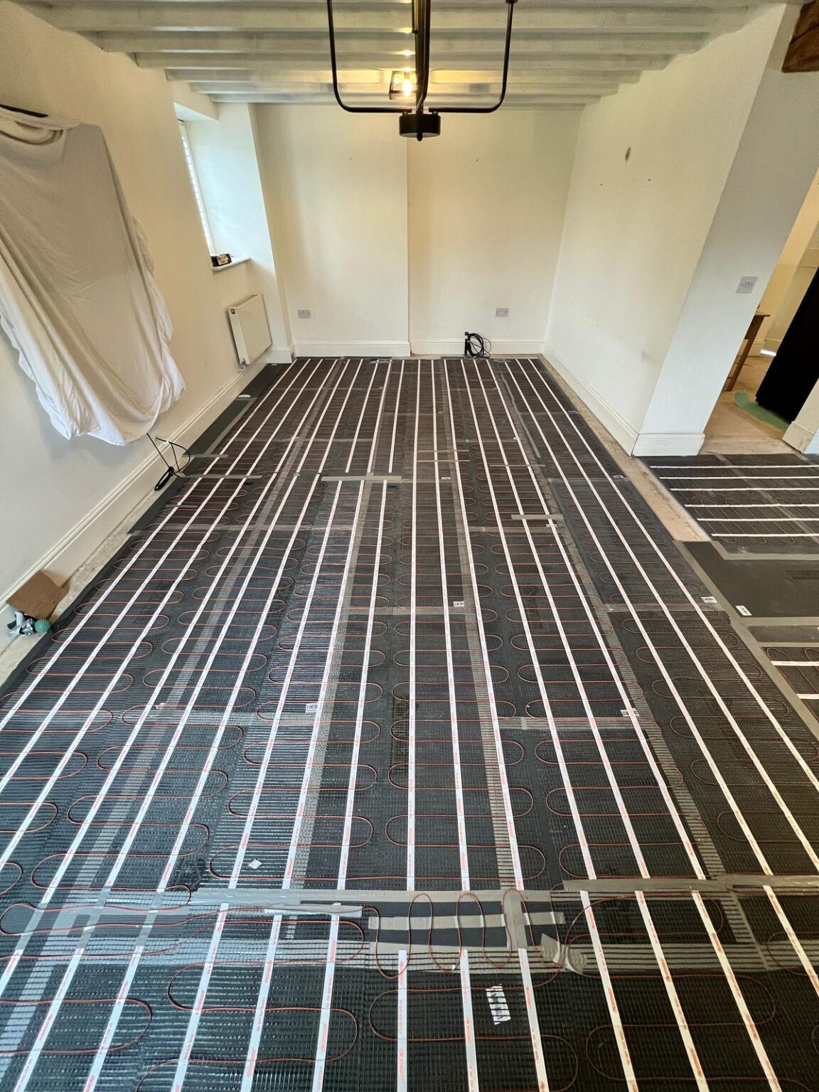 Underfloor heating installation in progress showing grid layout across a room