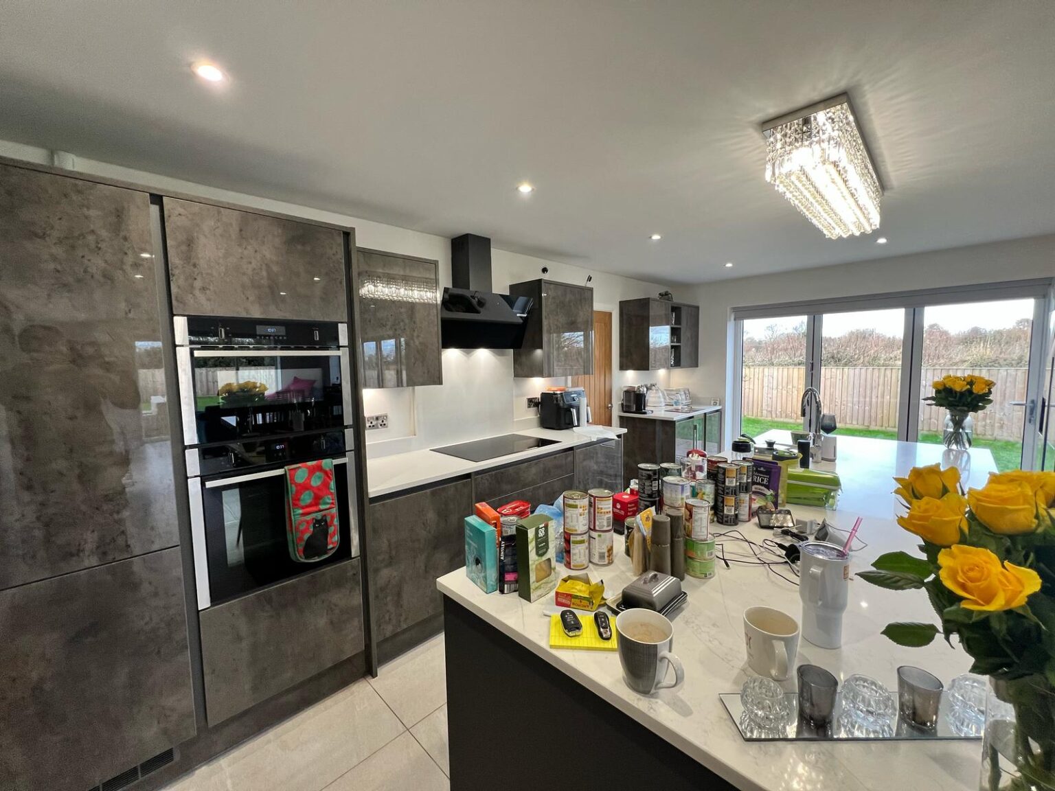 Contemporary kitchen with gloss cabinets, island worktop, and large sliding patio doors
